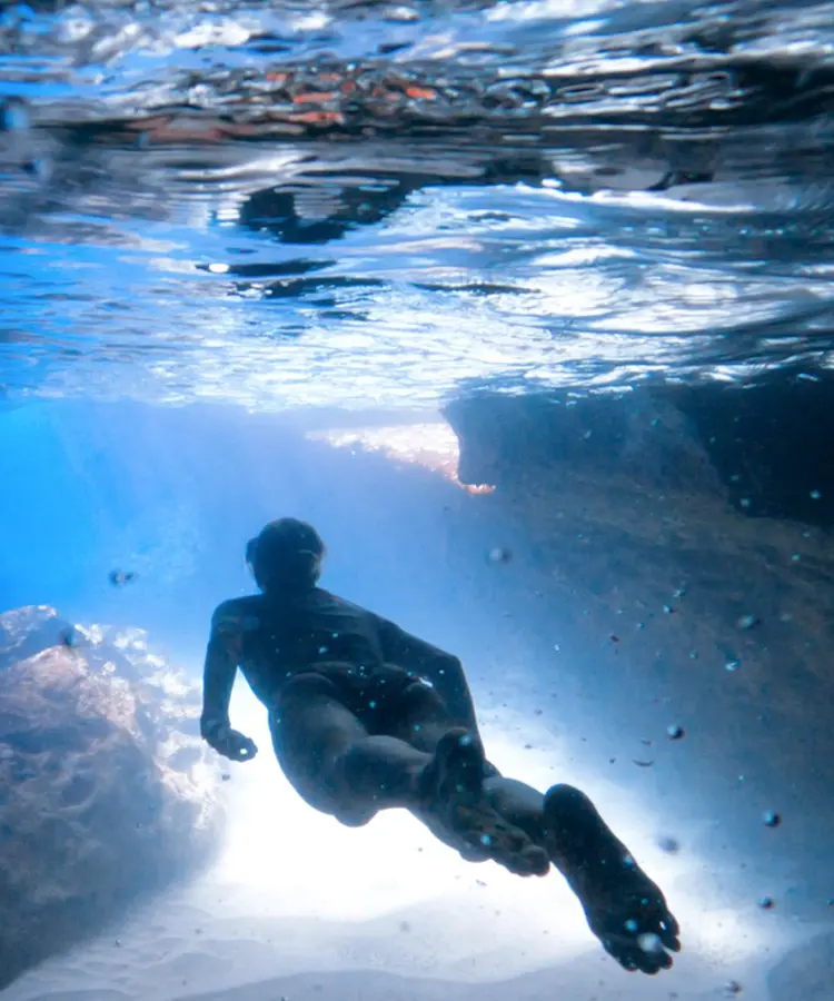A man swimming in the ocean under water.