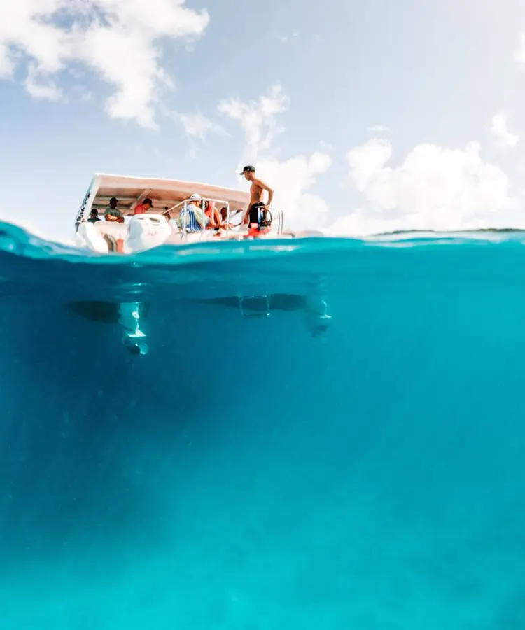 A boat floating in the ocean with people on it.