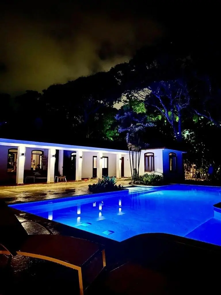 A pool with lights on in the night time.