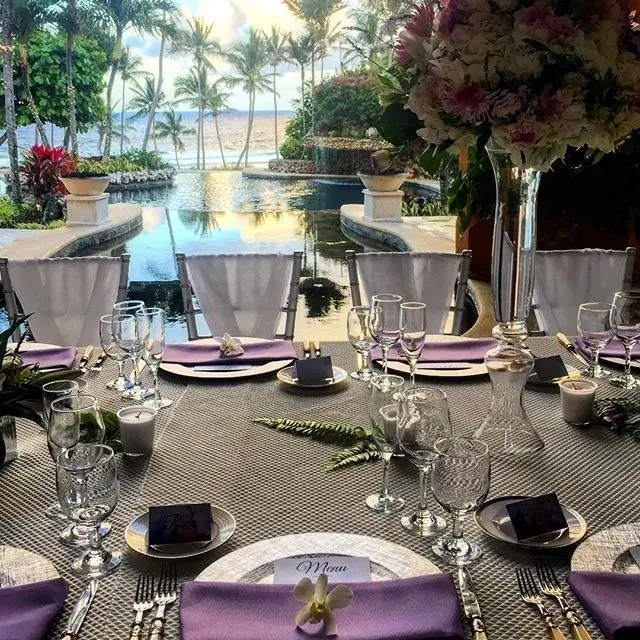A table set with purple napkins and silverware.
