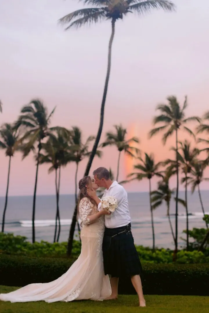 A couple is kissing in front of the ocean.