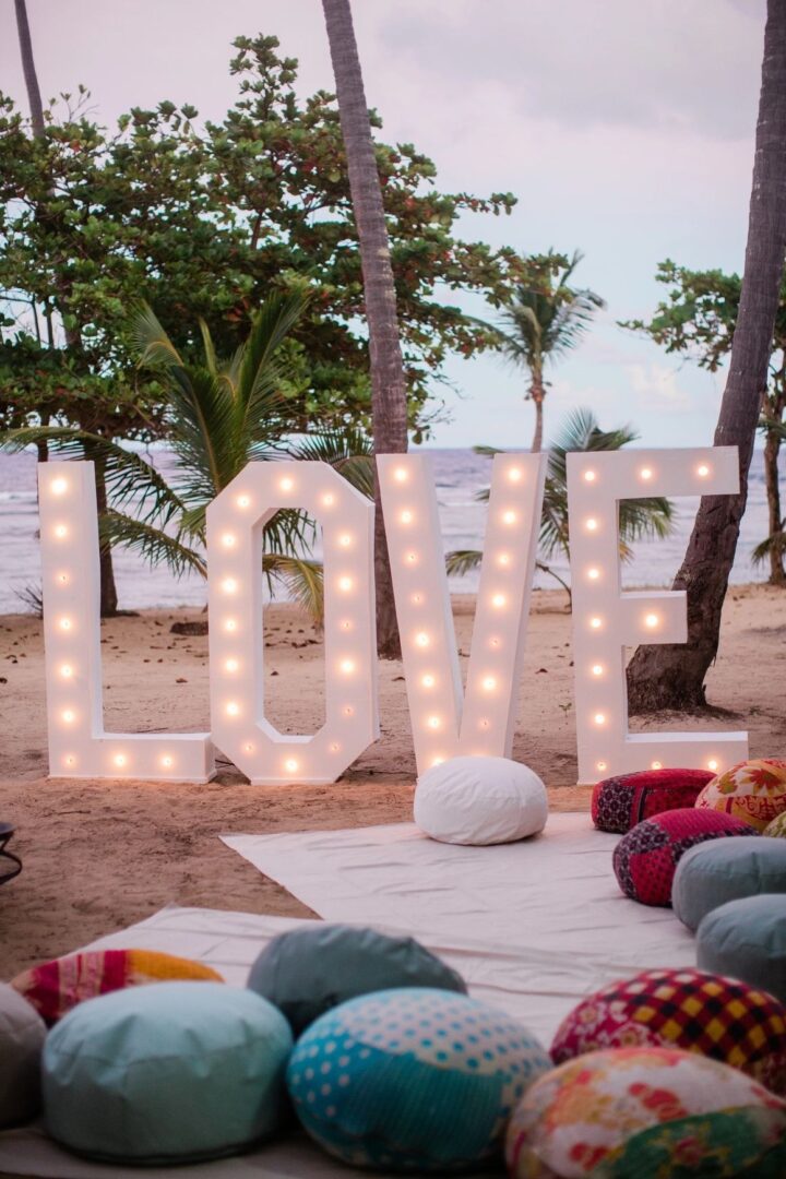 A large light up love sign on the beach