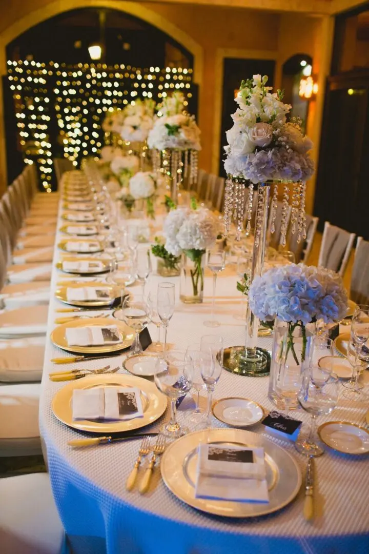 A long table with many plates and flowers