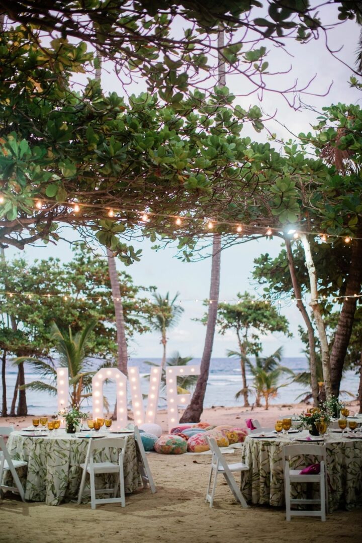 A beach wedding with lights and tables