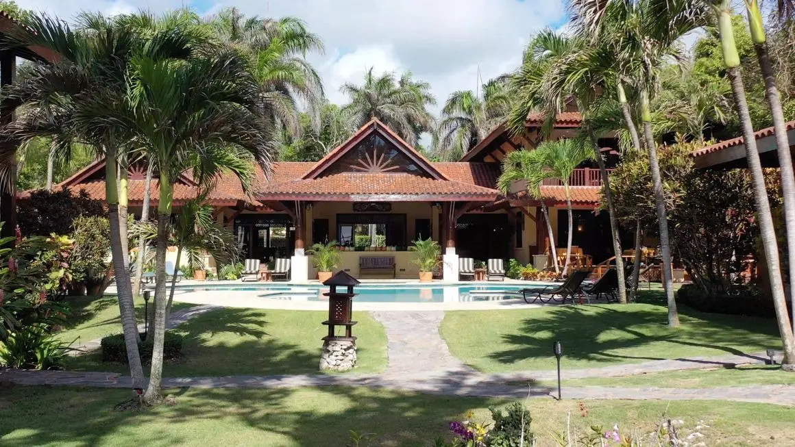 A large house with a pool and palm trees.