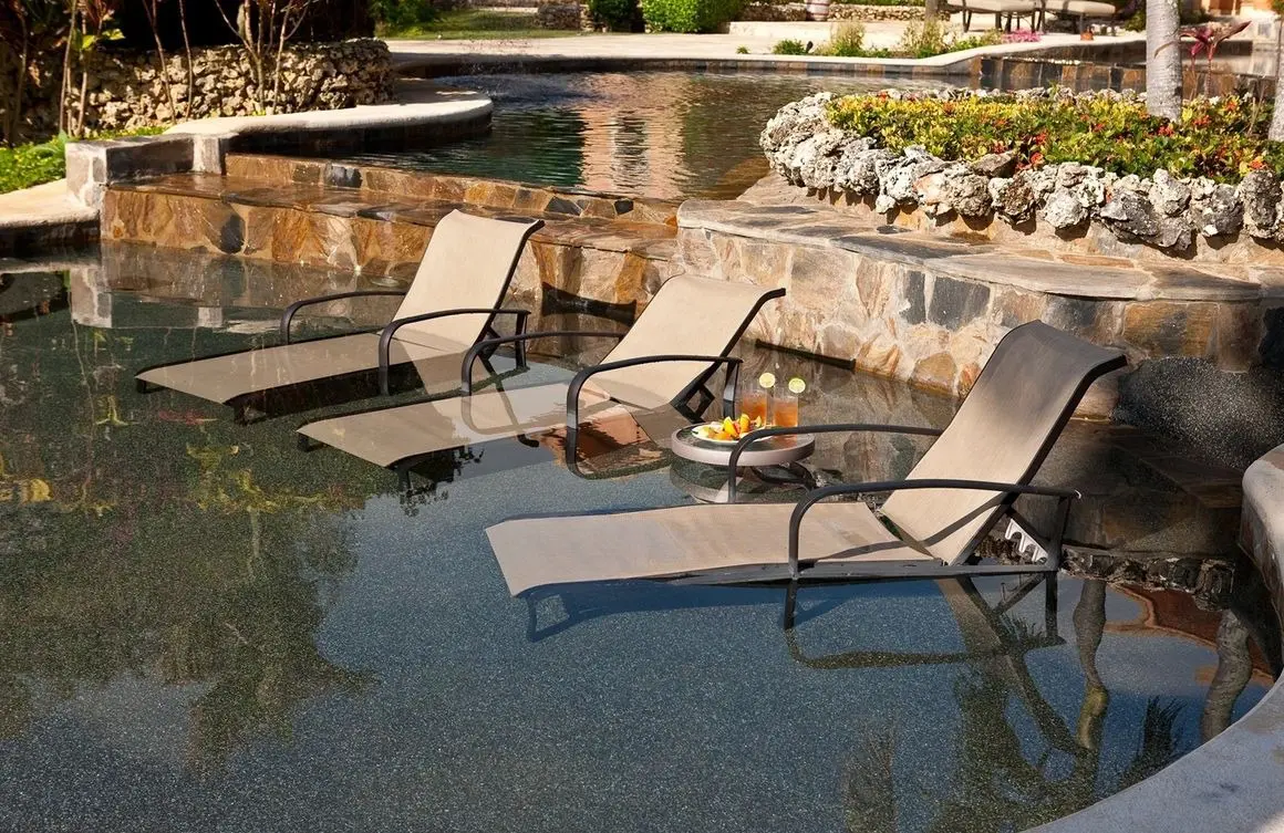 A pool with three chairs and a table in it