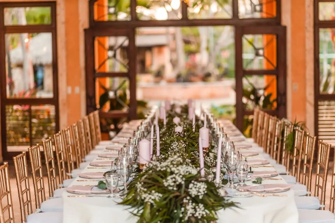 A long table with many glasses and candles on it