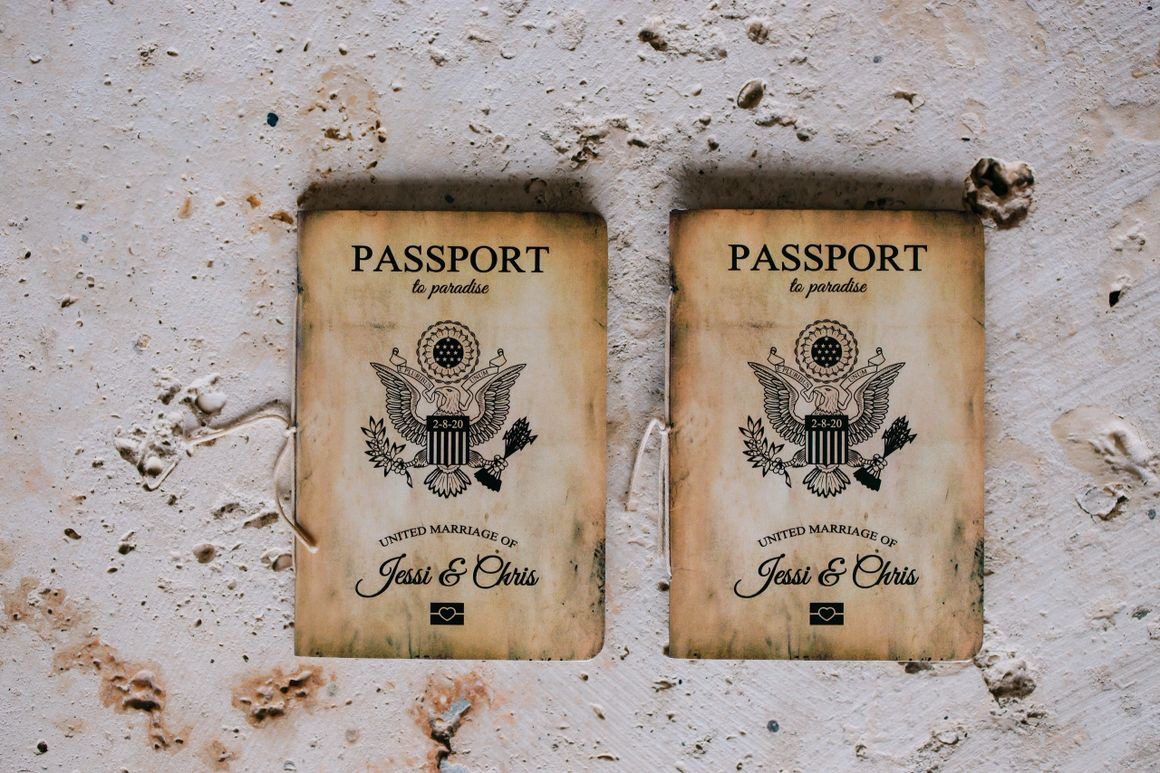Two passports are sitting on a wall.