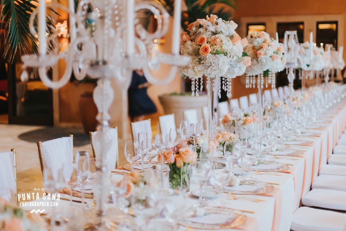 A long table with many white plates and flowers