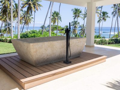 A concrete tub sitting on top of a wooden deck.